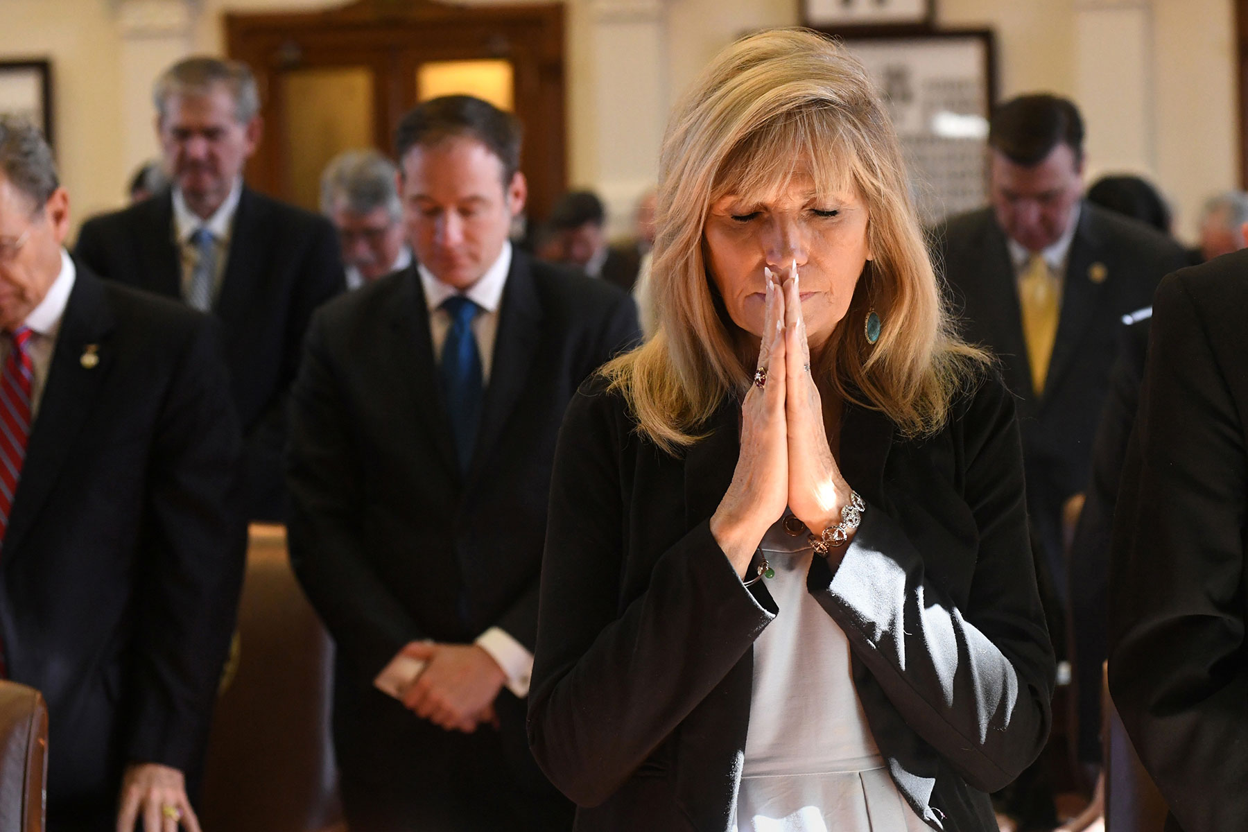 State Representatives pray during Opening Day proceedings for the 85th Texas Legislature