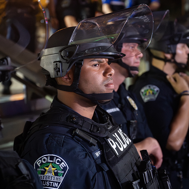Police line up outside their headquarters to watch over protesters