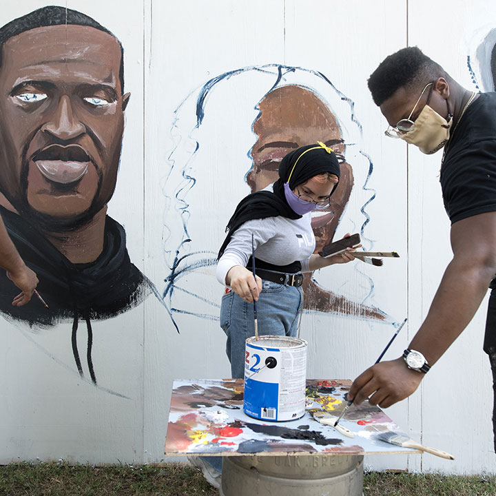 Participants paint murals during an event honoring George Floyd