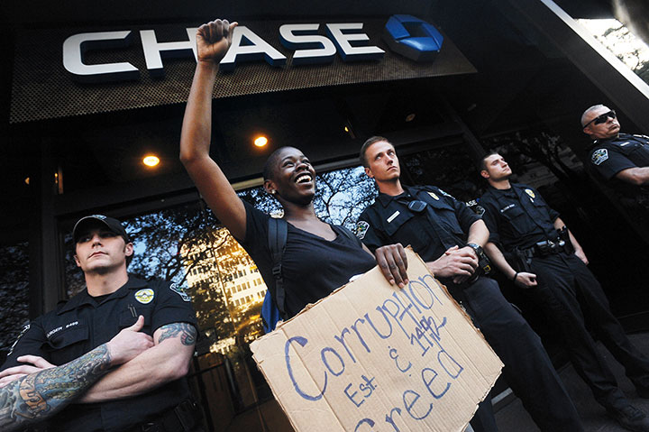 A protester speaks in front of Chase Bank in downtown Austin, Texas on October 10, 2011 as part of a push for a national Indigenous Peoples' Day.