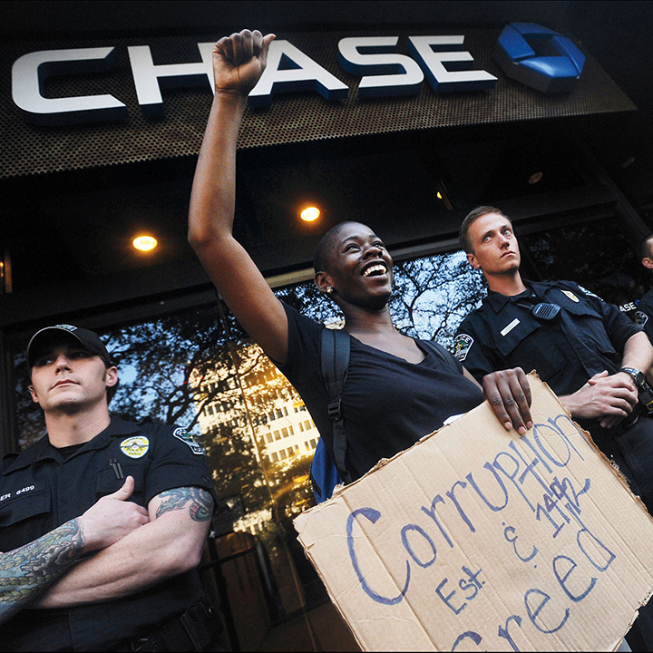 A protester speaks in front of Chase Bank in downtown Austin, Texas on October 10, 2011 as part of a push for a national Indigenous Peoples' Day.