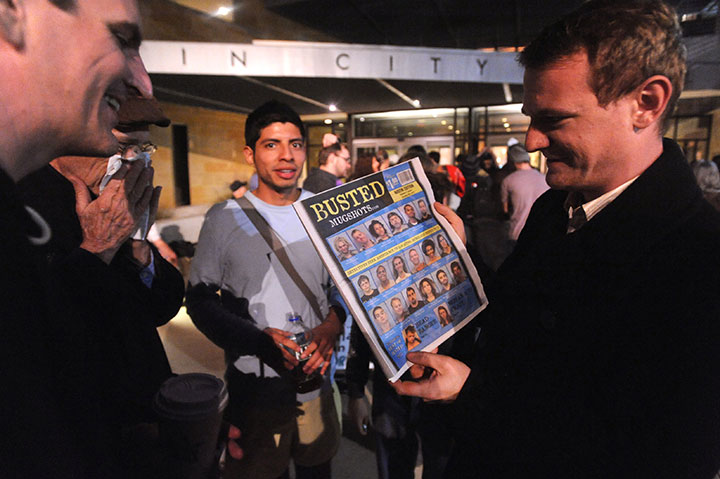 An Occupy Austin participant displays a copy of Busted Newspaper. The cover featured mugshots of some of the group’s arrested members