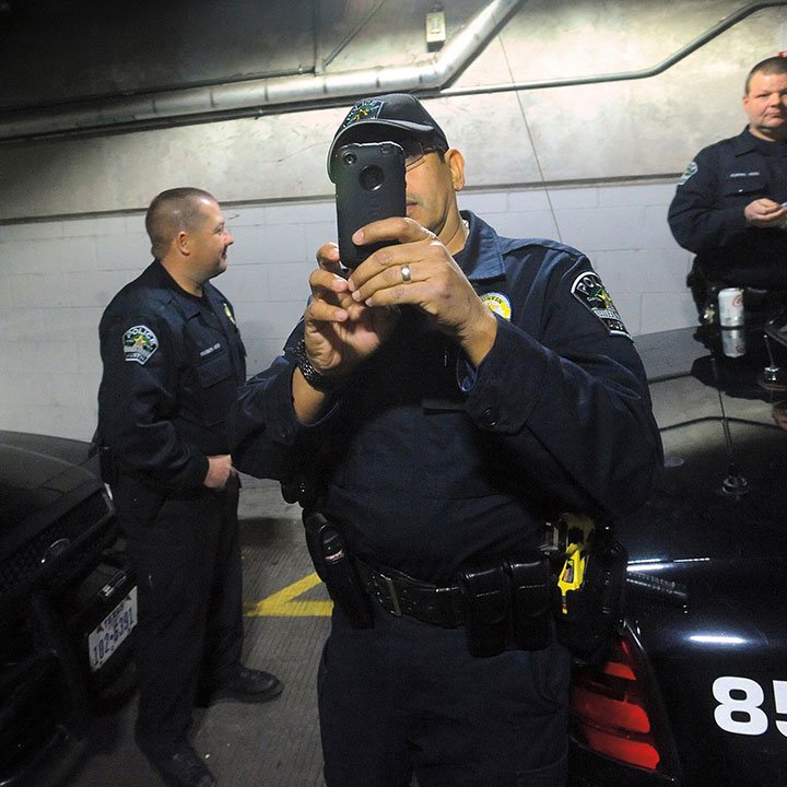 Police gather in the parking lot under City Hall