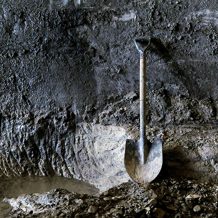 A shovel lays against a wall near the access shaft of the Waller Creek tunnel construction site